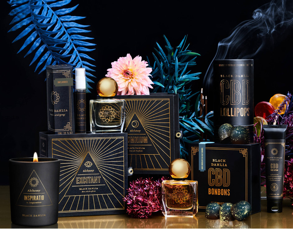 A collection of black and gold packaging of candles, perfume and candies for Black Dahlia CBD