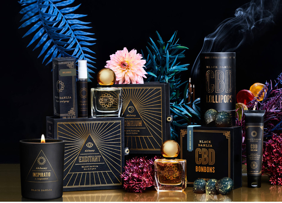 A collection of black and gold packaging of candles, perfume and candies for Black Dahlia CBD